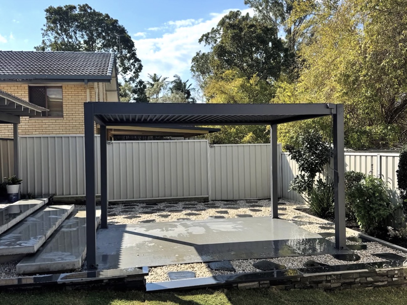 Completed outdoor entertainment area with louvred pergola and concrete terrace